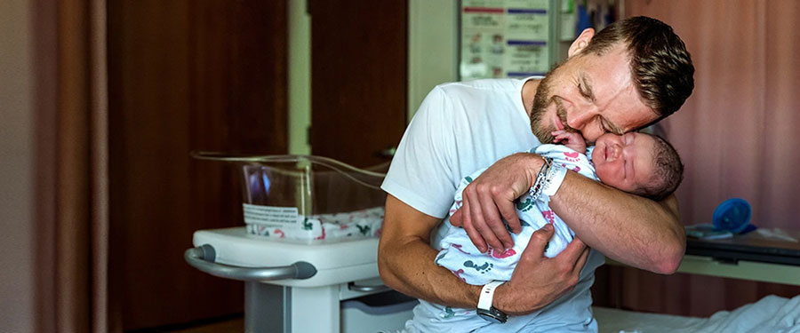 Father snuggling with his newborn baby